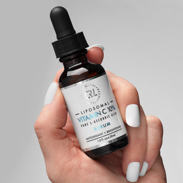 Clinical Resolution Lab Liposomal Vitamin C Serum 10% in hand on gray background