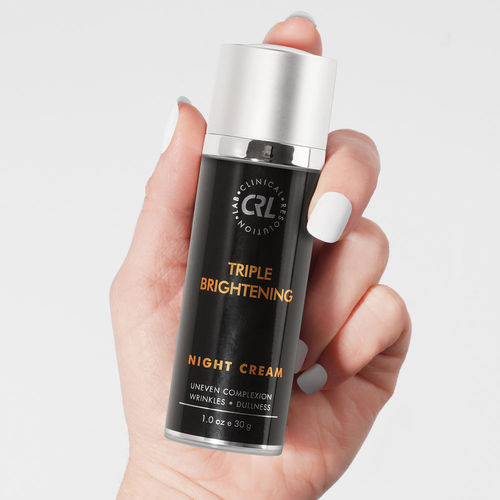 Triple Brightening Night Cream bottle with silver cap on a gray background