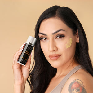 Woman holding a skincare product with a beige background